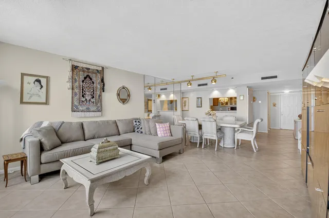 a kitchen with stainless steel appliances granite countertop a sink a stove a dining table chairs and chandelier