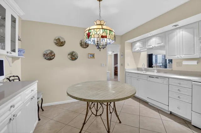 a living room with furniture kitchen view and large windows