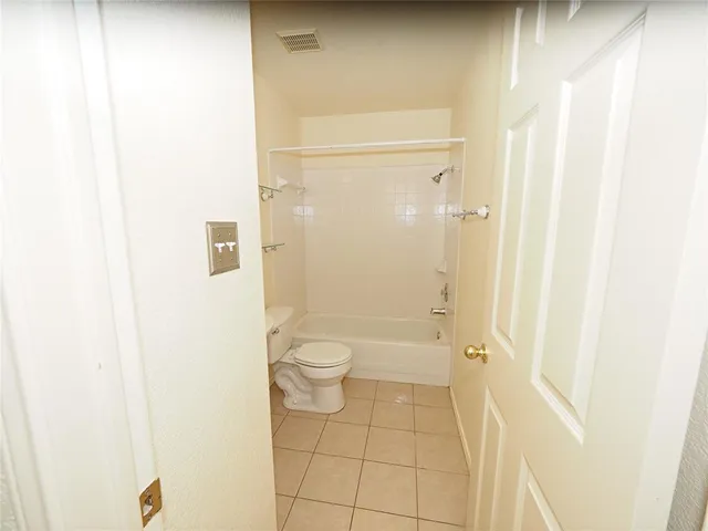 a bathroom with a granite countertop shower and a toilet