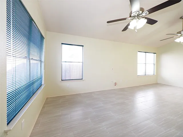 an empty room with windows and fan
