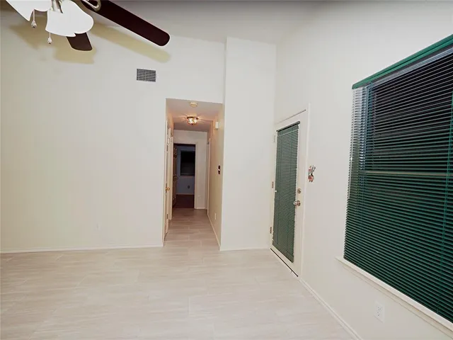 a view of an empty room with a kitchen