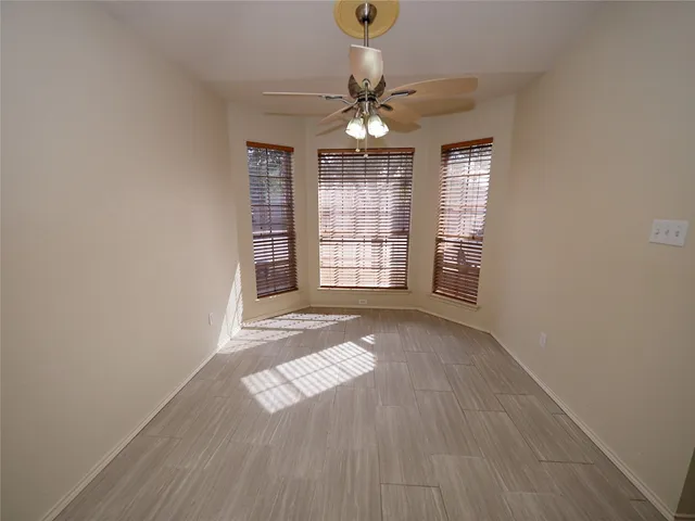 a view of empty room with window and wooden floor
