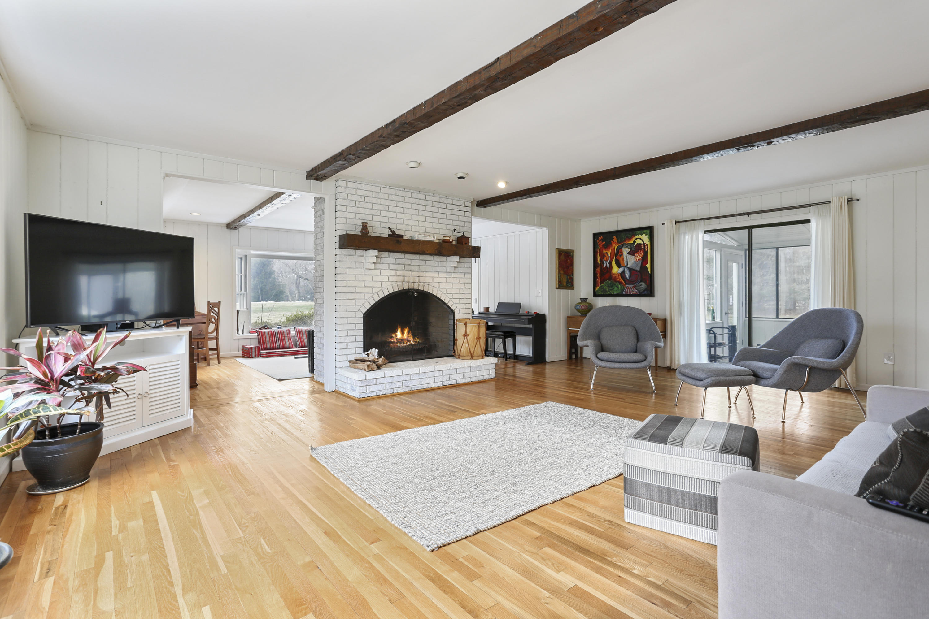 507 Brookside Road New Canaan, CT 06840 - Photo 16 of 36 a living room with furniture flat screen tv and a fireplace