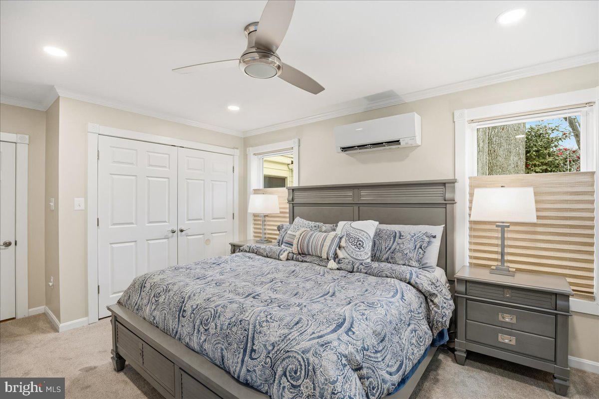 14382 Sedwick Avenue Solomons, MD 20688 - Photo 19 of 90 a bedroom with a large bed and a chandelier