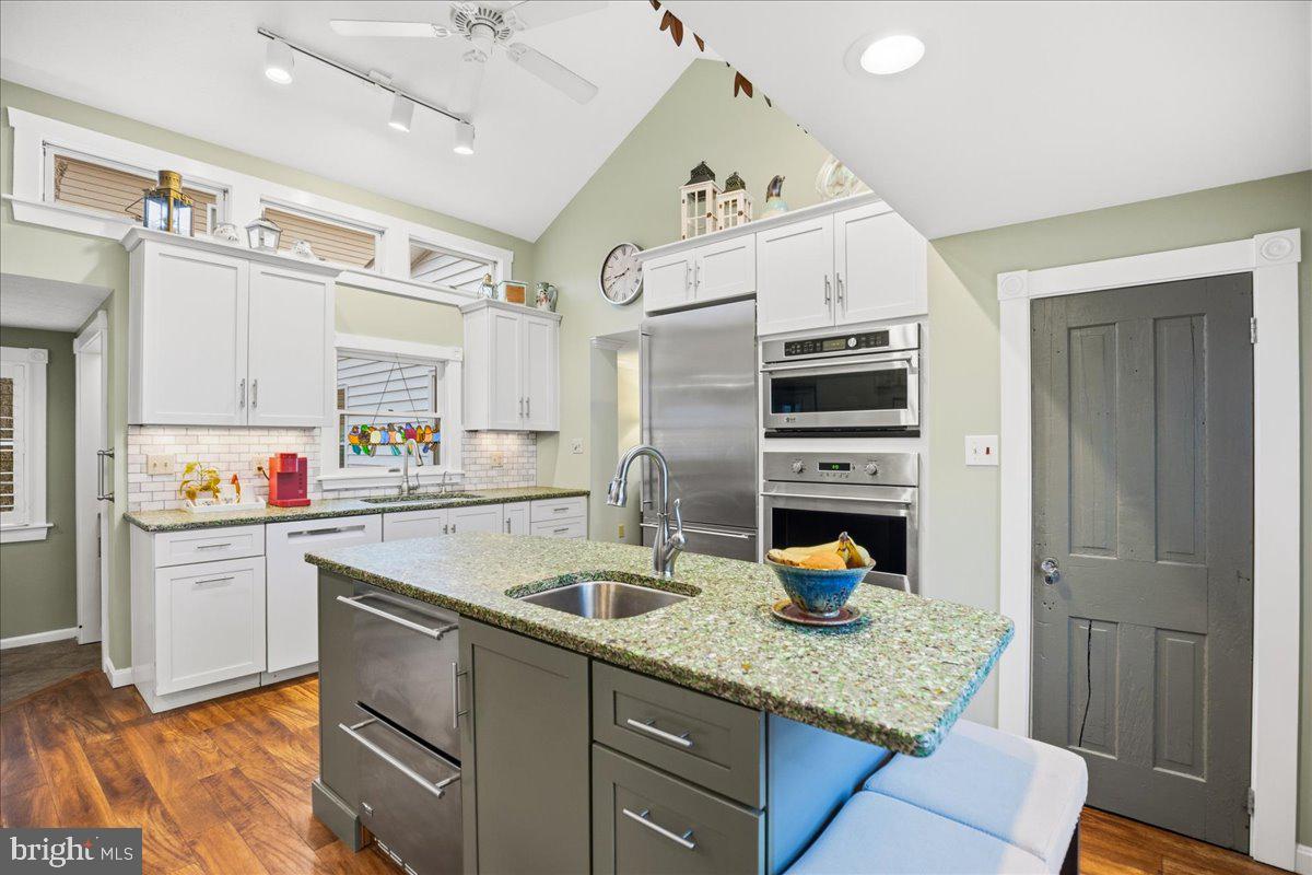 14382 Sedwick Avenue Solomons, MD 20688 - Photo 34 of 90 a kitchen with a sink dishwasher and a refrigerator with wooden cabinets