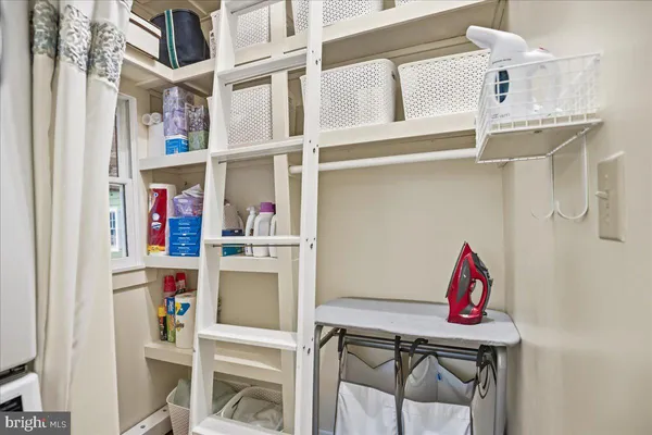 a living room with furniture kitchen view and a wooden floor