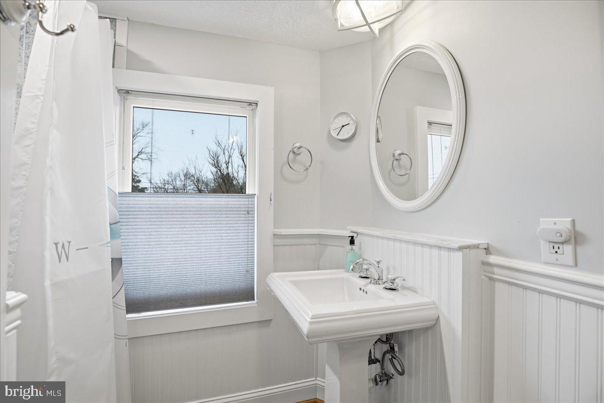 14382 Sedwick Avenue Solomons, MD 20688 - Photo 47 of 90 a bathroom with a sink a mirror and a shower