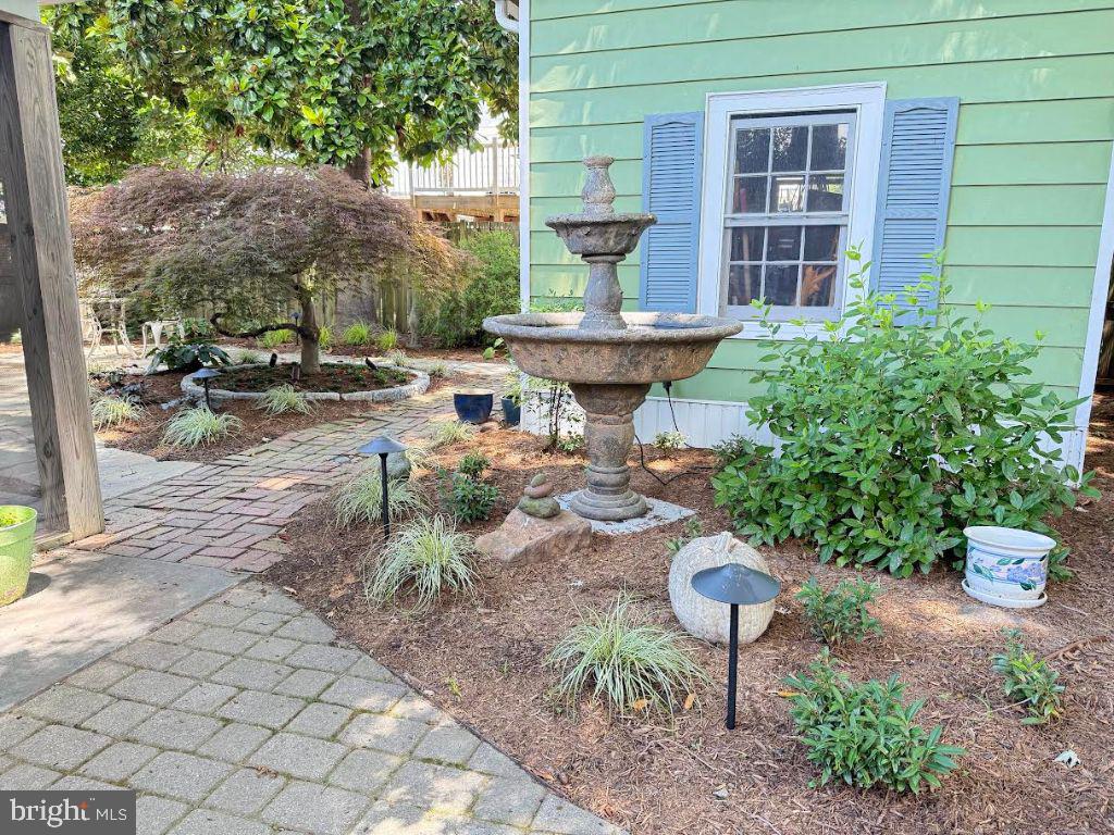 14382 Sedwick Avenue Solomons, MD 20688 - Photo 55 of 90 a view of a backyard with table and chairs potted plants and a fountain