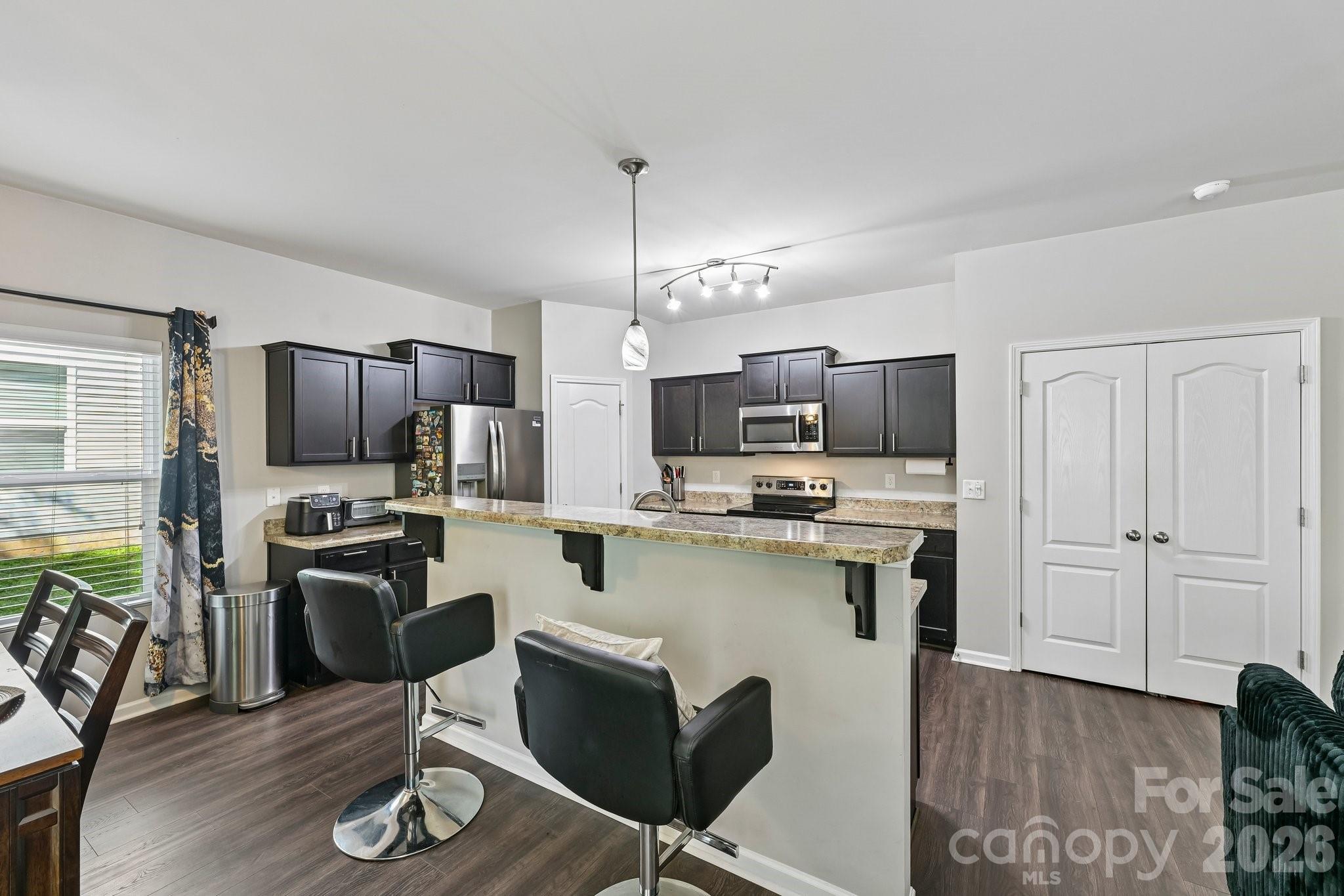 2206 Turtle Point Road Charlotte, NC 28262 - Photo 8 of 28 a kitchen with refrigerator a stove and chairs