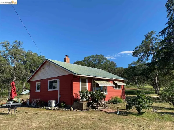 a view of backyard of house and car parked