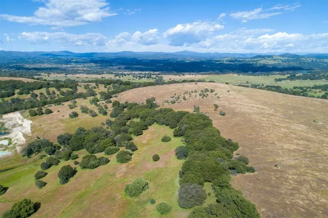 an aerial view of a house with a yard and lake view