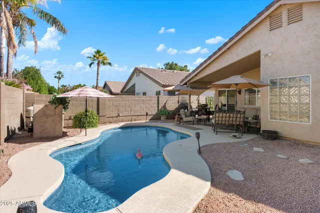 a view of a house with swimming pool and sitting area