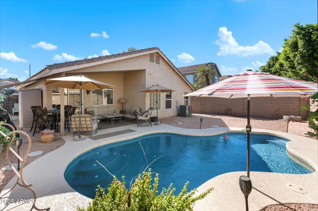 a view of a house with swimming pool and sitting area