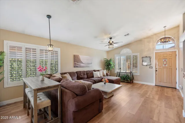 a living room with furniture a chandelier and a wooden floor