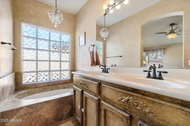 a spacious bathroom with a bathtub a double vanity sink and a mirror