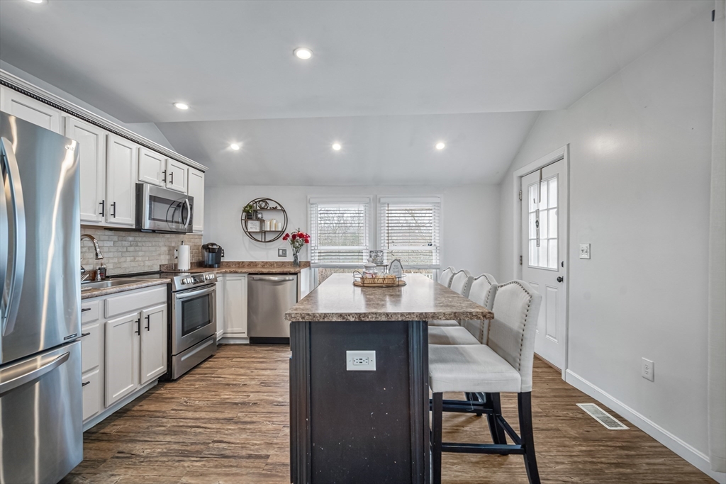 182 Wrentham Road Springfield, MA 01119 - Photo 11 of 25 a kitchen with stainless steel appliances granite countertop a stove top oven a sink dishwasher a dining table and chairs with wooden floor