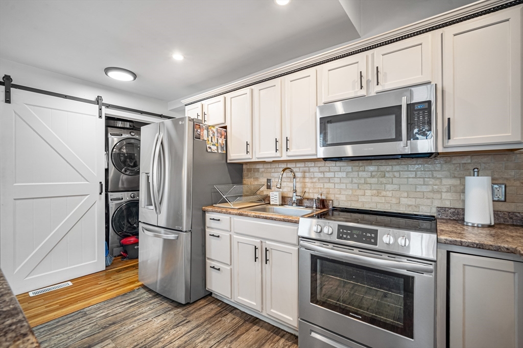 182 Wrentham Road Springfield, MA 01119 - Photo 13 of 25 a kitchen with refrigerator a microwave and cabinets