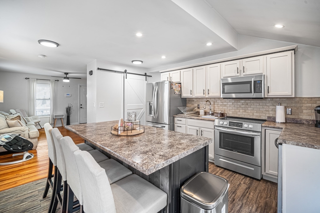 182 Wrentham Road Springfield, MA 01119 - Photo 9 of 25 a kitchen with granite countertop kitchen island stainless steel appliances a stove a sink a table and chairs