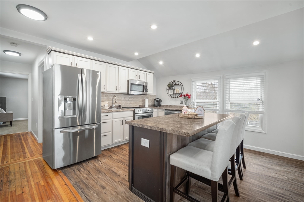 182 Wrentham Road Springfield, MA 01119 - Photo 10 of 25 a kitchen with stainless steel appliances granite countertop a refrigerator a stove top oven a sink dishwasher and a dining table with wooden floor