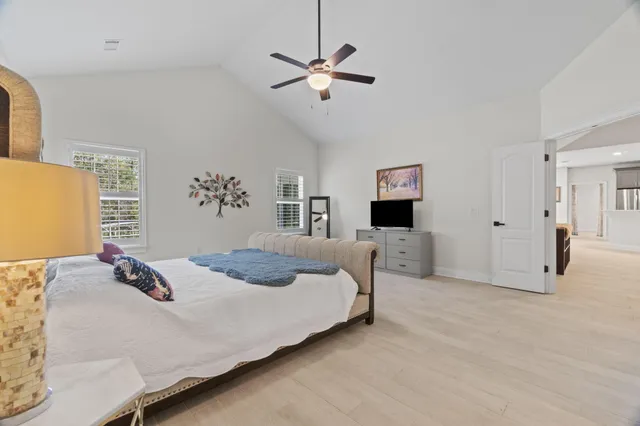 a bedroom with a large bed and a chandelier