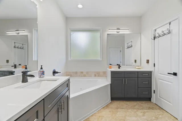 a bathroom with a tub sink and mirror
