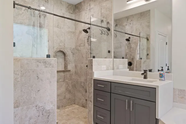 a bathroom with a double vanity sink mirror and shower