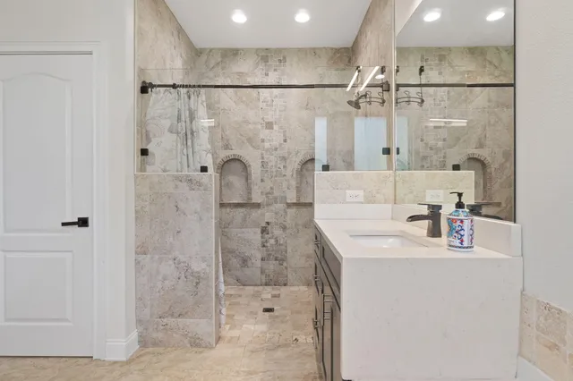 a bathroom with a shower sink and mirror