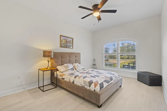 a view of a bedroom with a bed and wooden floor