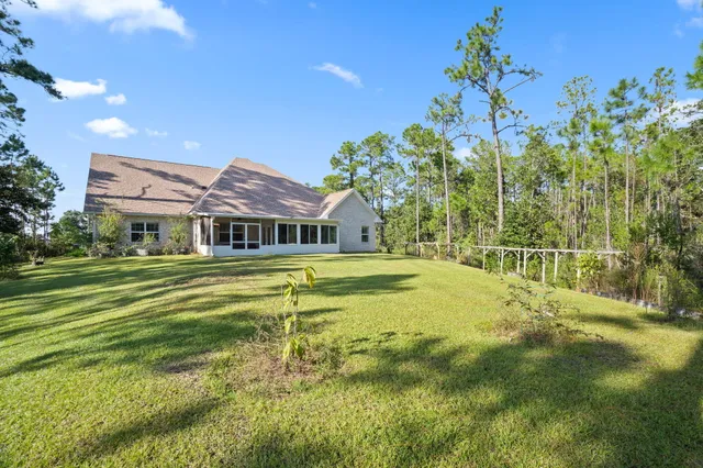 an aerial view of a house with a yard and lake view