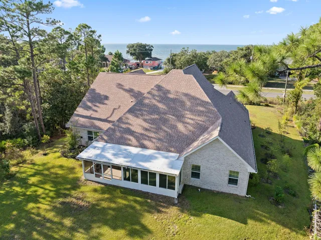 a view of a balcony with wooden floor and a couple of cars parked on road
