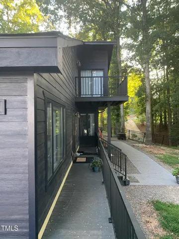a view of an empty room with window chandelier fan and wooden floor