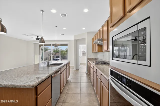 a large kitchen with stainless steel appliances granite countertop a stove and a sink