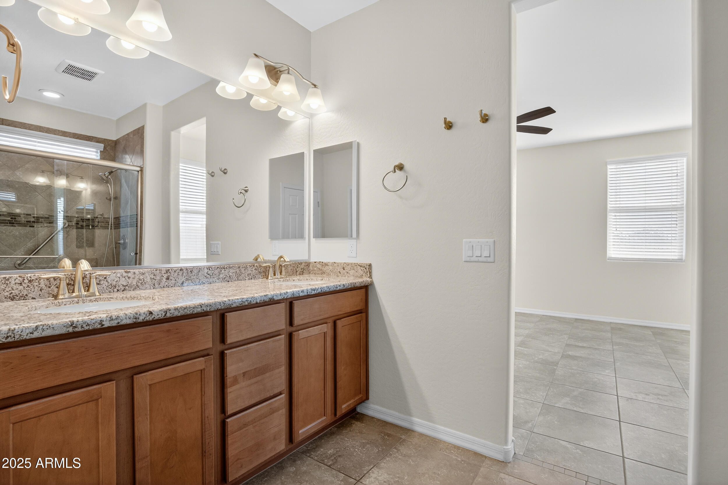 17763 West Granite View Drive Goodyear, AZ 85338 - Photo 23 of 67 a bathroom with a granite countertop sink a large mirror and a shower