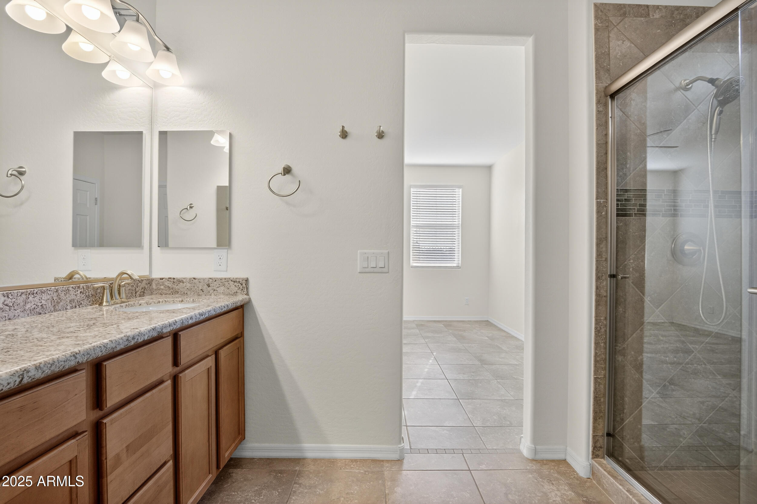 17763 West Granite View Drive Goodyear, AZ 85338 - Photo 24 of 67 a bathroom with a granite countertop sink a mirror and shower