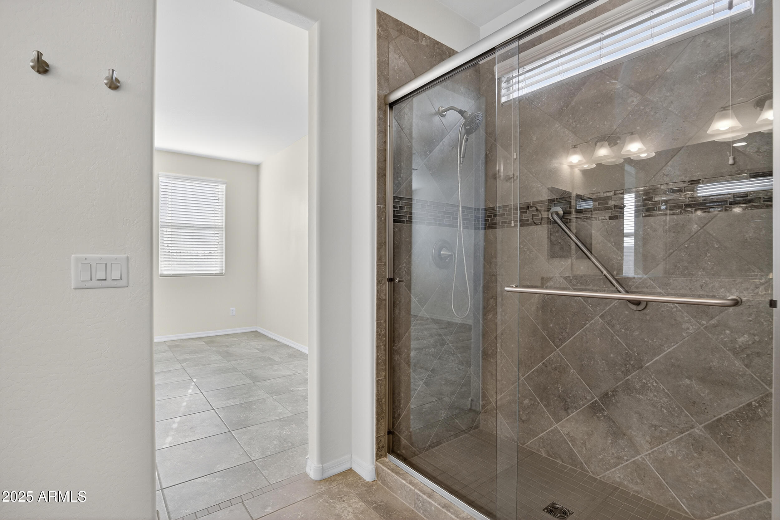 17763 West Granite View Drive Goodyear, AZ 85338 - Photo 25 of 67 a bathroom with a glass shower door