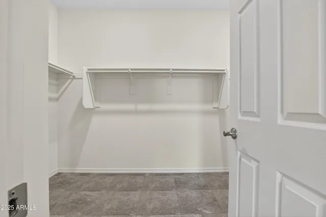 an empty room with a window and ceiling fan
