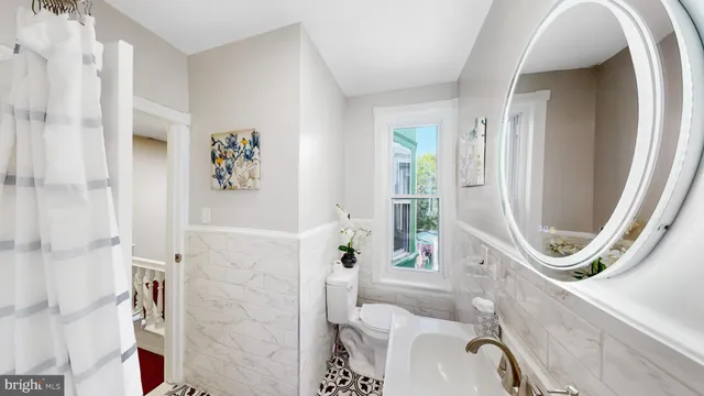 a bathroom with a sink a toilet and a mirror