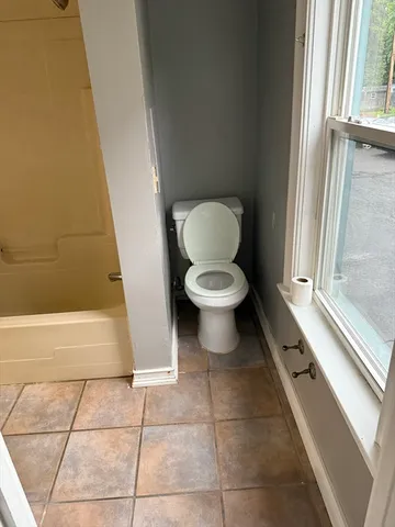 a bathroom with a toilet and a shower