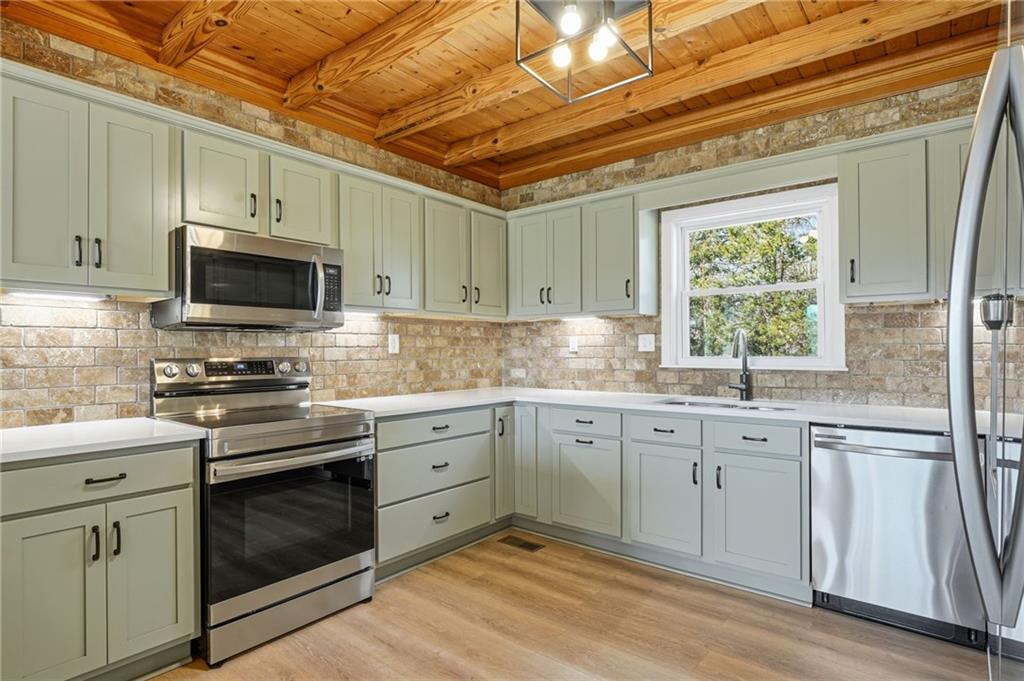858 Honeysuckle Lane Temple, GA 30179 - Photo 23 of 60 a kitchen with granite countertop a sink stainless steel appliances and cabinets