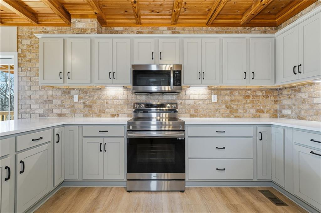 858 Honeysuckle Lane Temple, GA 30179 - Photo 25 of 60 a kitchen with granite countertop white cabinets and stainless steel appliances