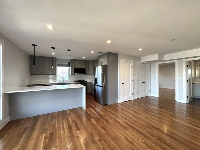 a open kitchen with stainless steel appliances granite countertop a refrigerator and a sink