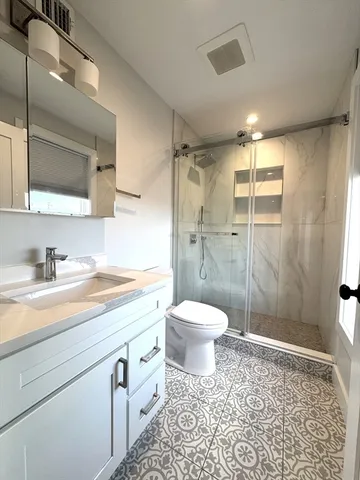 a bathroom with a toilet a sink and shower