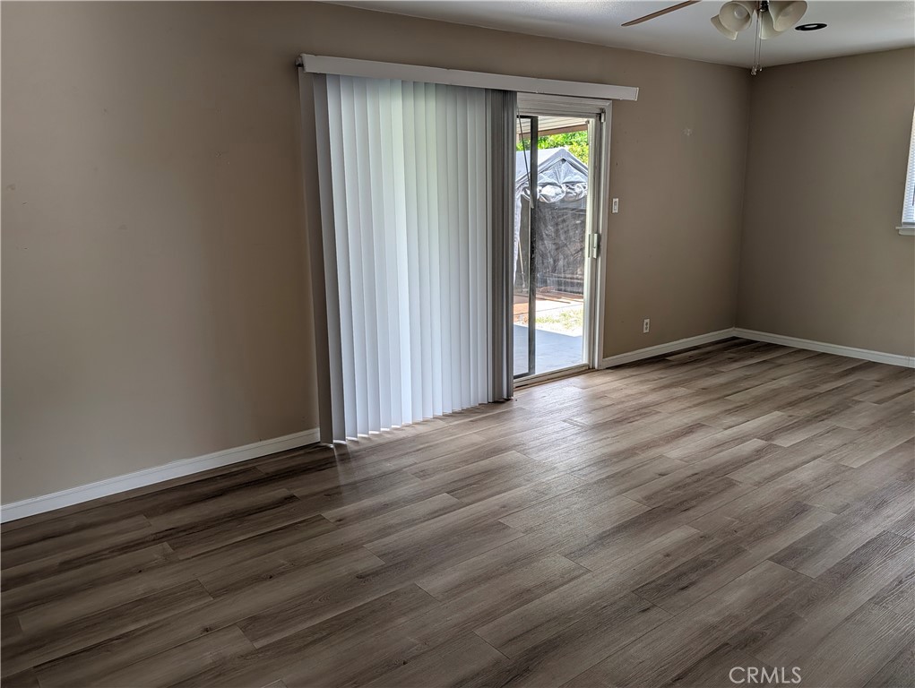 8641 Garfield Street Riverside, CA 92504 - Photo 7 of 19 an empty room with wooden floor and windows