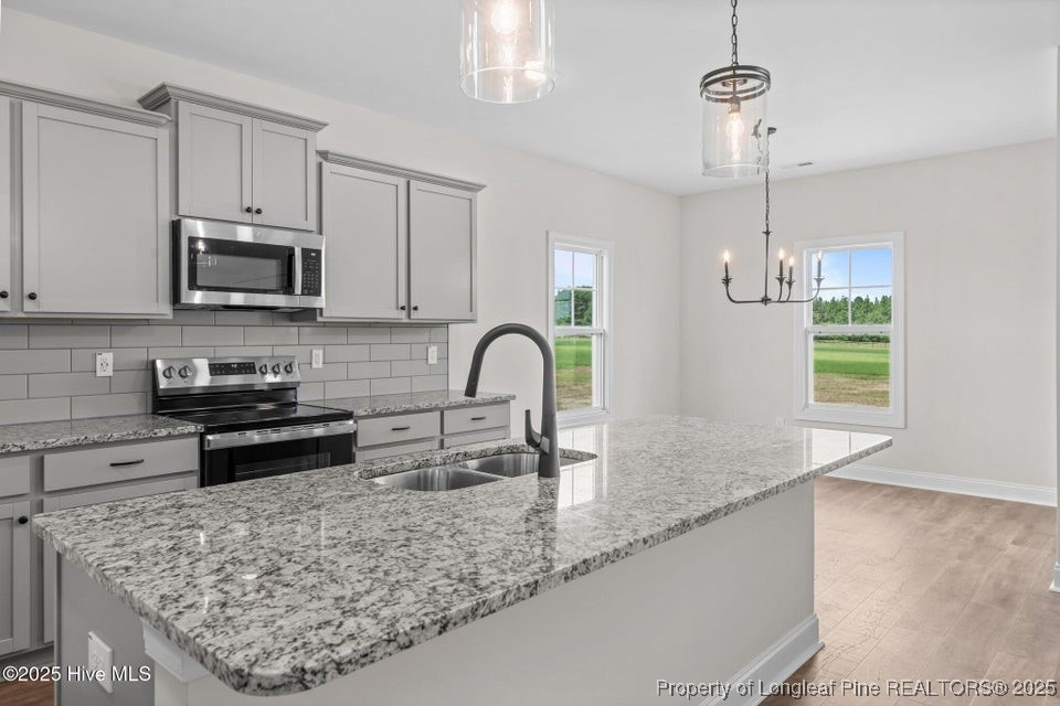 334 Mcbride Road Jackson Springs, NC 27281 - Photo 15 of 47 a kitchen with stainless steel appliances granite countertop a sink a stove top oven a counter space and cabinets