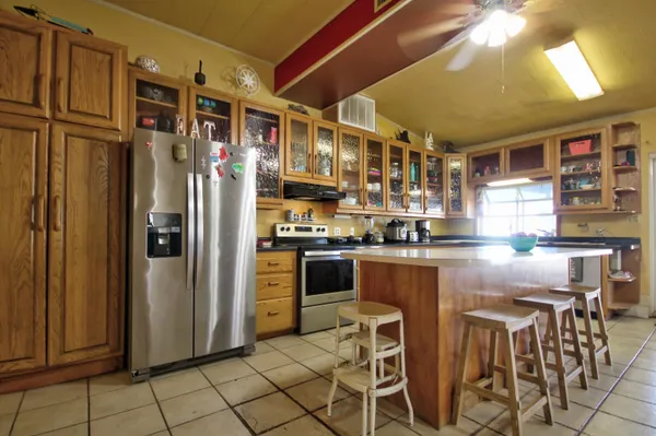 a kitchen with stainless steel appliances granite countertop a refrigerator and a stove top oven