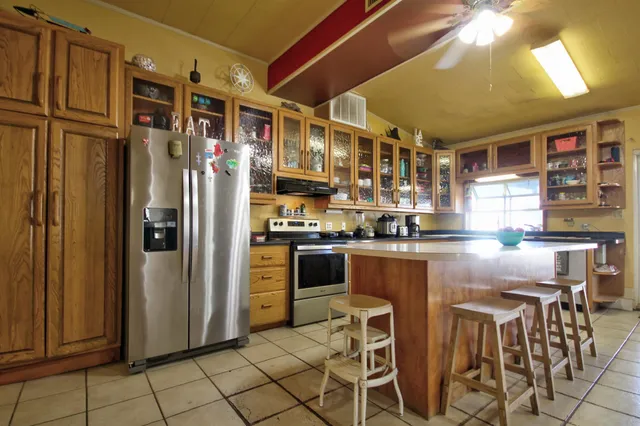 a kitchen with stainless steel appliances granite countertop a refrigerator and a stove top oven