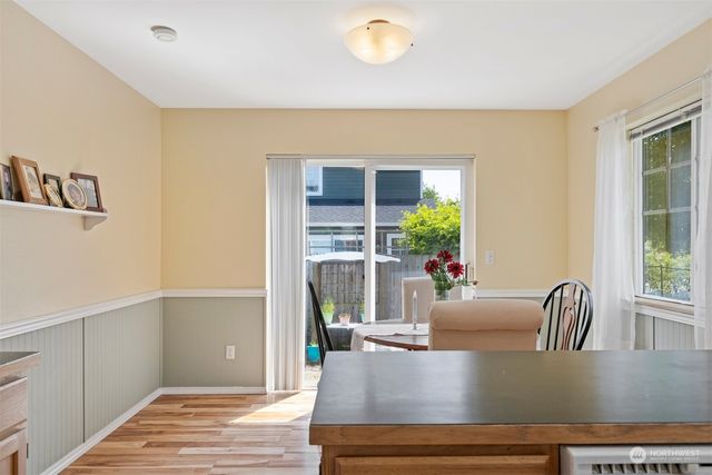 a kitchen with stainless steel appliances granite countertop a refrigerator a stove and white cabinets with wooden floor