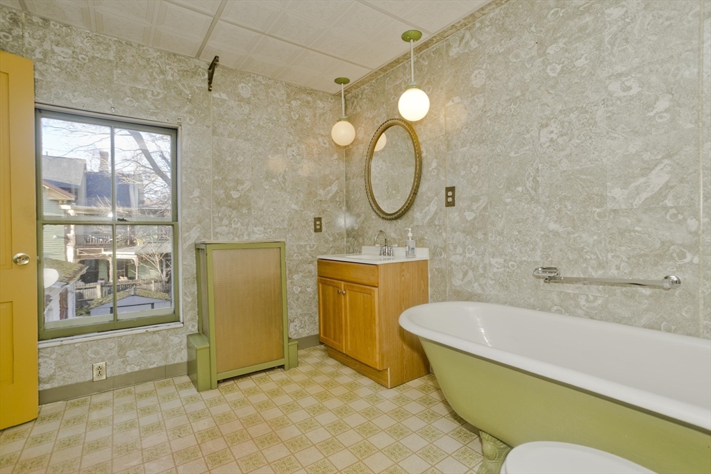 115 Thompson Street Springfield, MA 01109 - Photo 27 of 39 a bathroom with a granite countertop bathtub sink and mirror