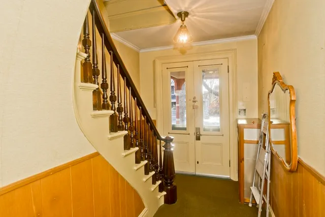 a view of an empty room with window and stairs