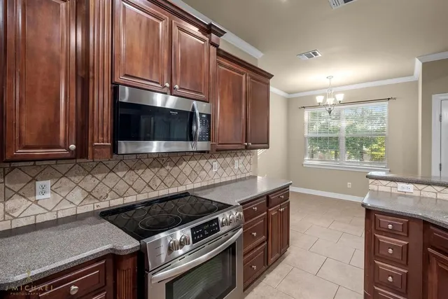a kitchen with granite countertop a stove and a microwave